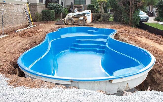 A fiberglass pool set in the ground without any concrete around it.