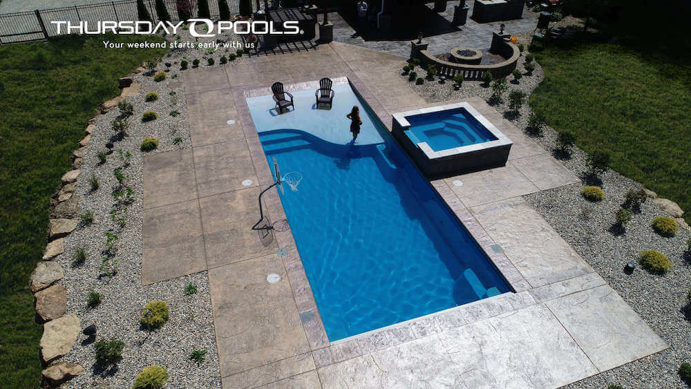 inground pool from Thursday Pools with stamped concrete around