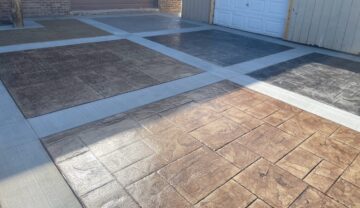 Photo of an area in front of a garage featuring six squares of different stamped designs and colors.