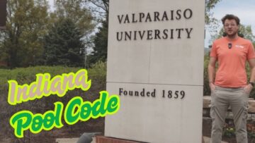 Man standing next to Valparaiso University sign