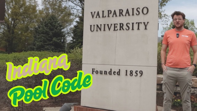 Man standing next to Valparaiso University sign