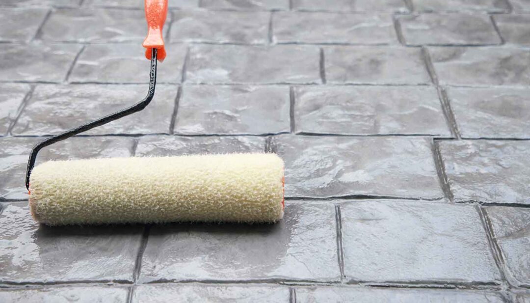 A fabric rolling tool rolling a sealer liquid onto stamped concrete.