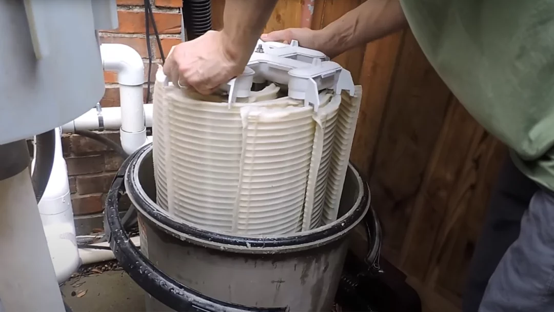 Clean d.e. grids being put back inside a d.e. filter shell.